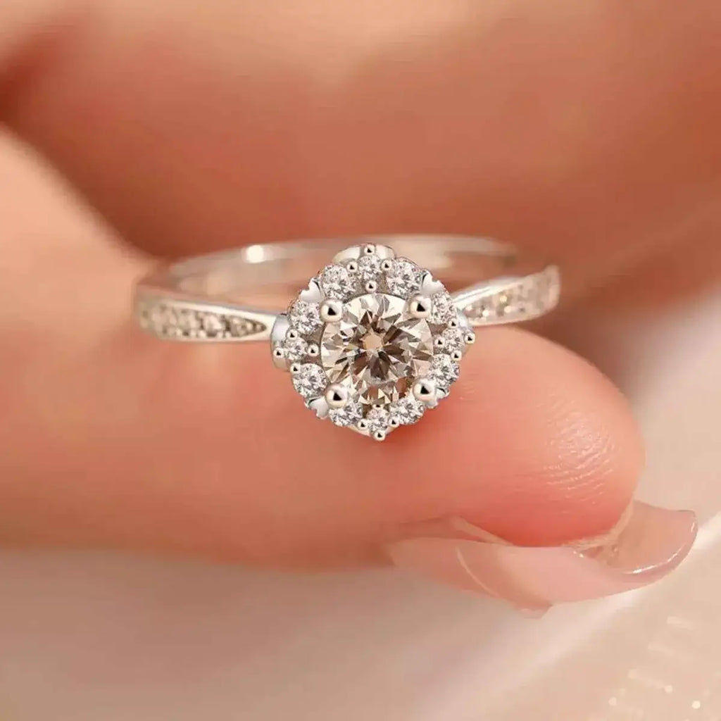 1 Carat Moissanite sterling silver ring with a round center stone surrounded by smaller stones in a halo setting