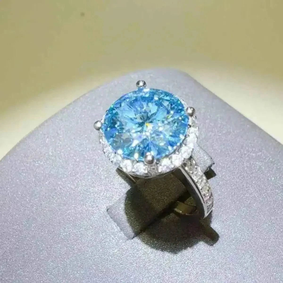 925 sterling silver ring with a large blue 1 Carat Moissanite center stone surrounded by smaller clear stones
