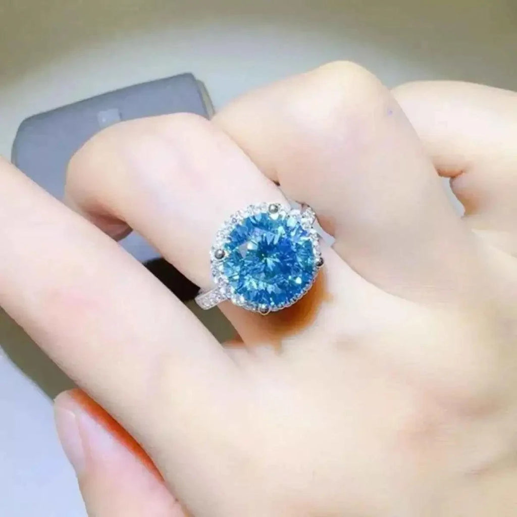 1 Carat Moissanite ring with a large round blue stone set in 925 sterling silver band featuring small clear stones