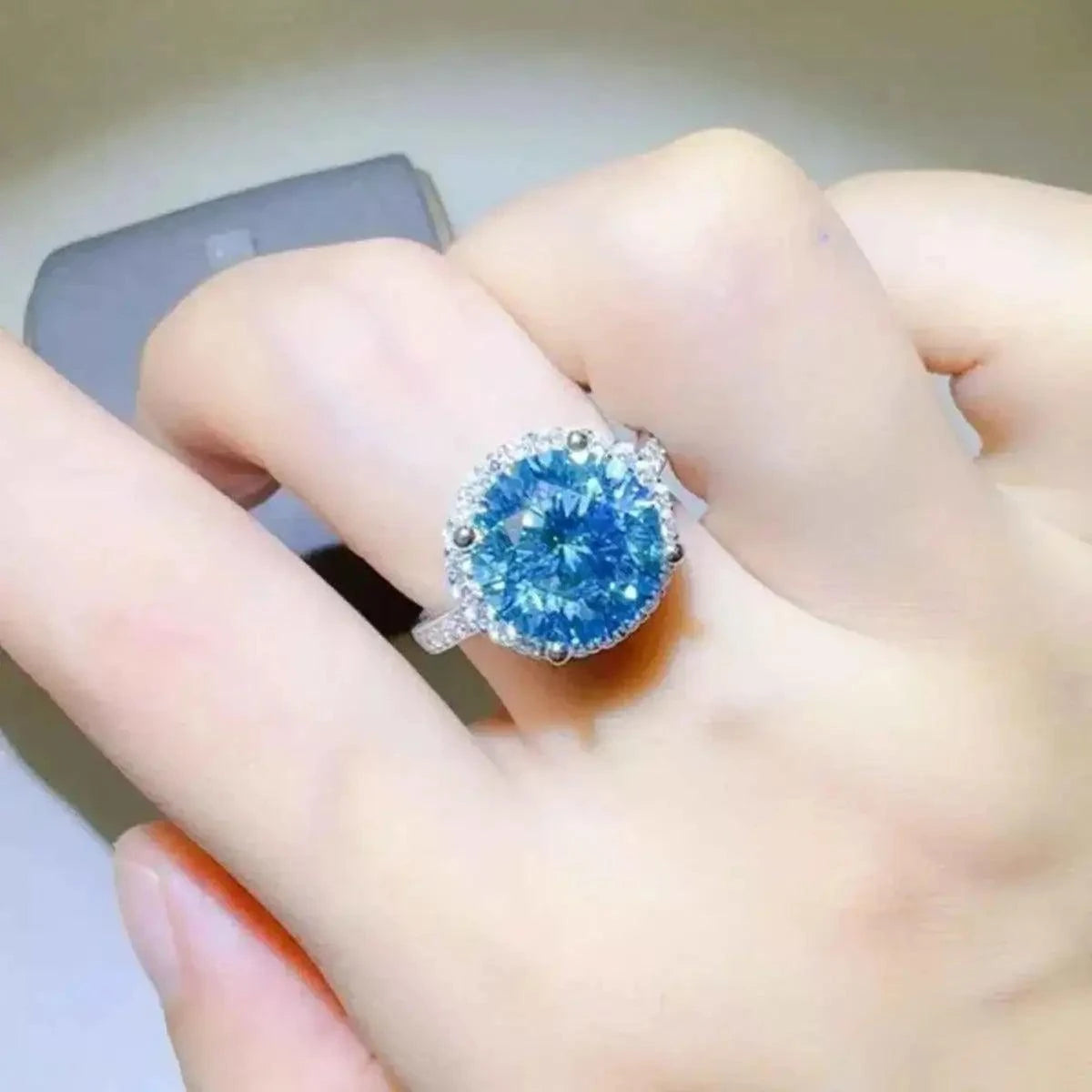 1 Carat Moissanite ring with a large round blue stone set in 925 sterling silver band featuring small clear stones
