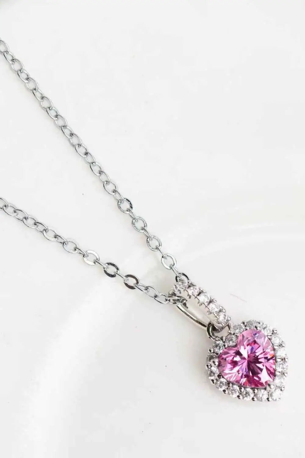1 Carat Moissanite heart pendant necklace with a pink heart-shaped moissanite surrounded by small zircons on a silver chain