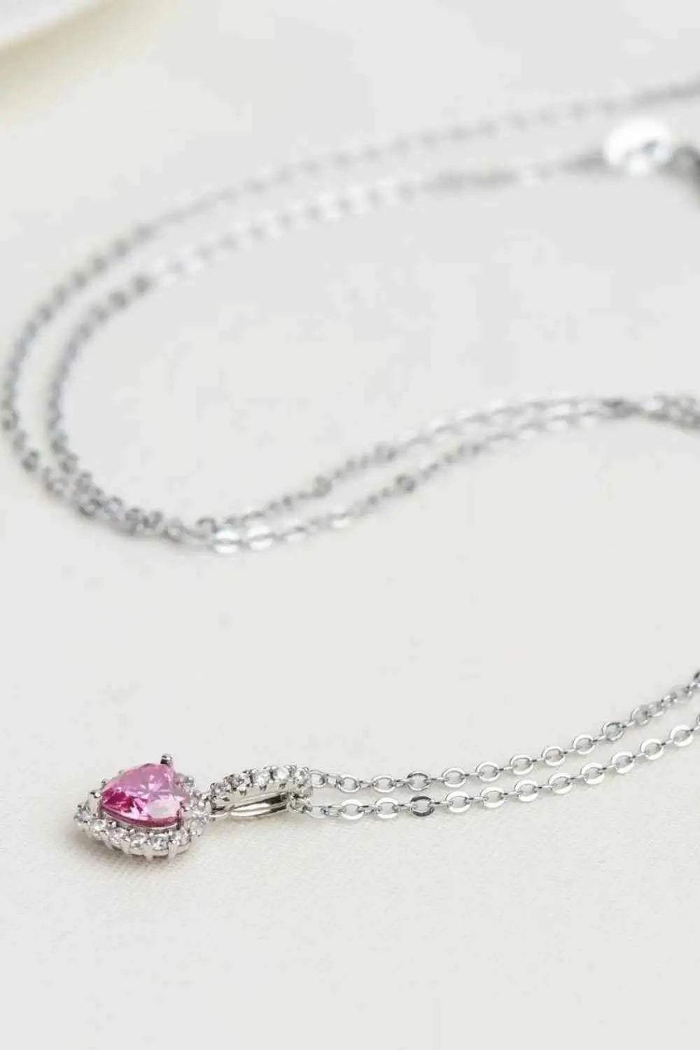 1 Carat Moissanite heart pendant necklace with pink heart-shaped moissanite surrounded by small clear stones on a silver chain