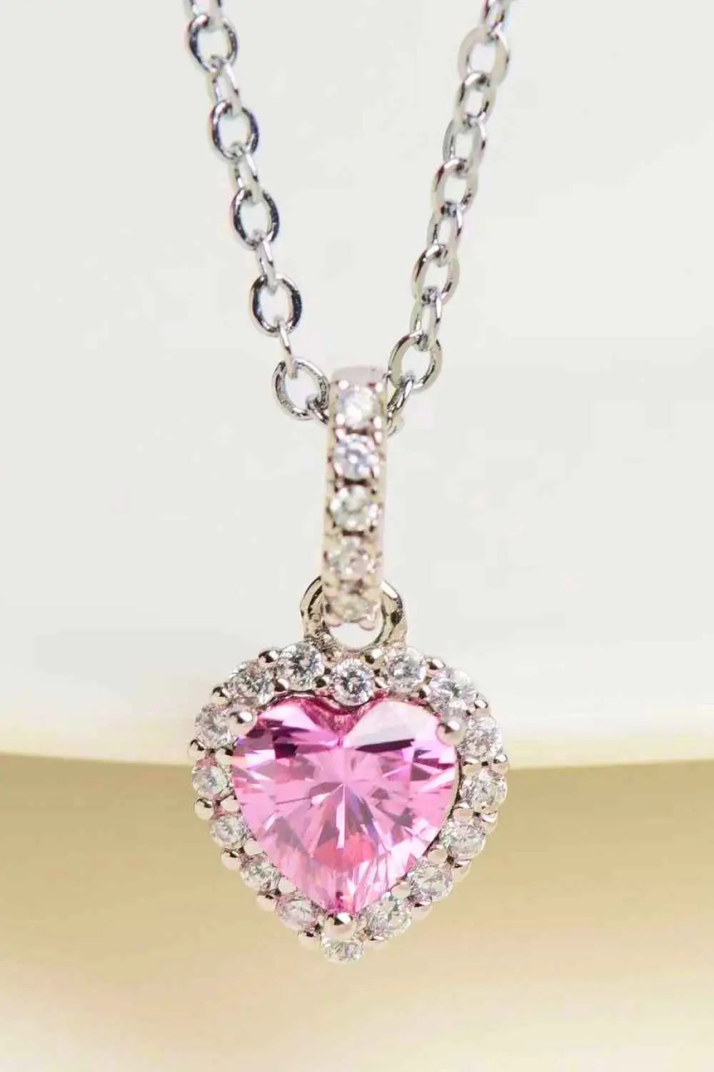 1 Carat Moissanite heart pendant necklace with a pink heart-shaped moissanite center surrounded by clear zircon stones on a sterling silver chain