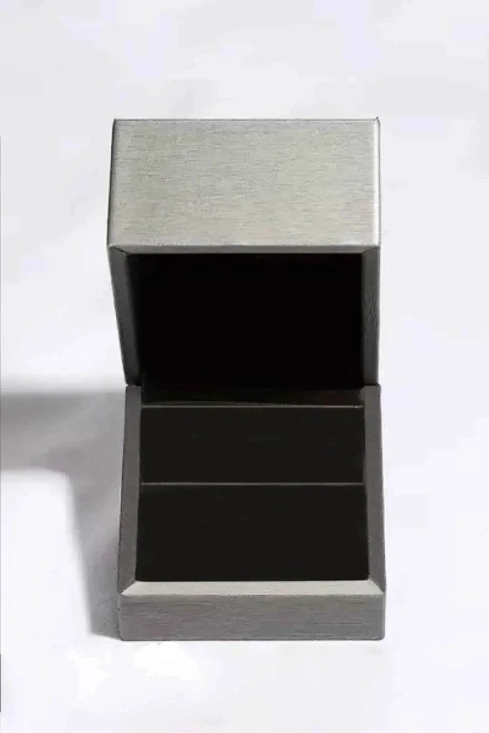 Open silver metal jewelry box with black velvet interior, designed to hold a 10.5 Carat Moissanite ring securely.
