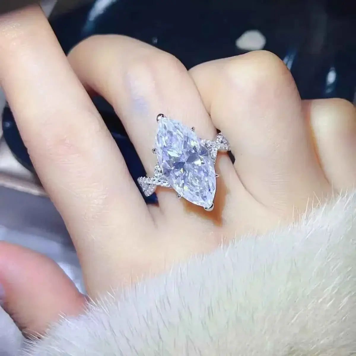 10 Carat Moissanite sterling silver ring with a large marquise-cut clear stone and smaller accent stones on the band