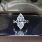 10 Carat Moissanite ring with a large marquise-cut stone set in silver with a twisted band design and small accent stones.