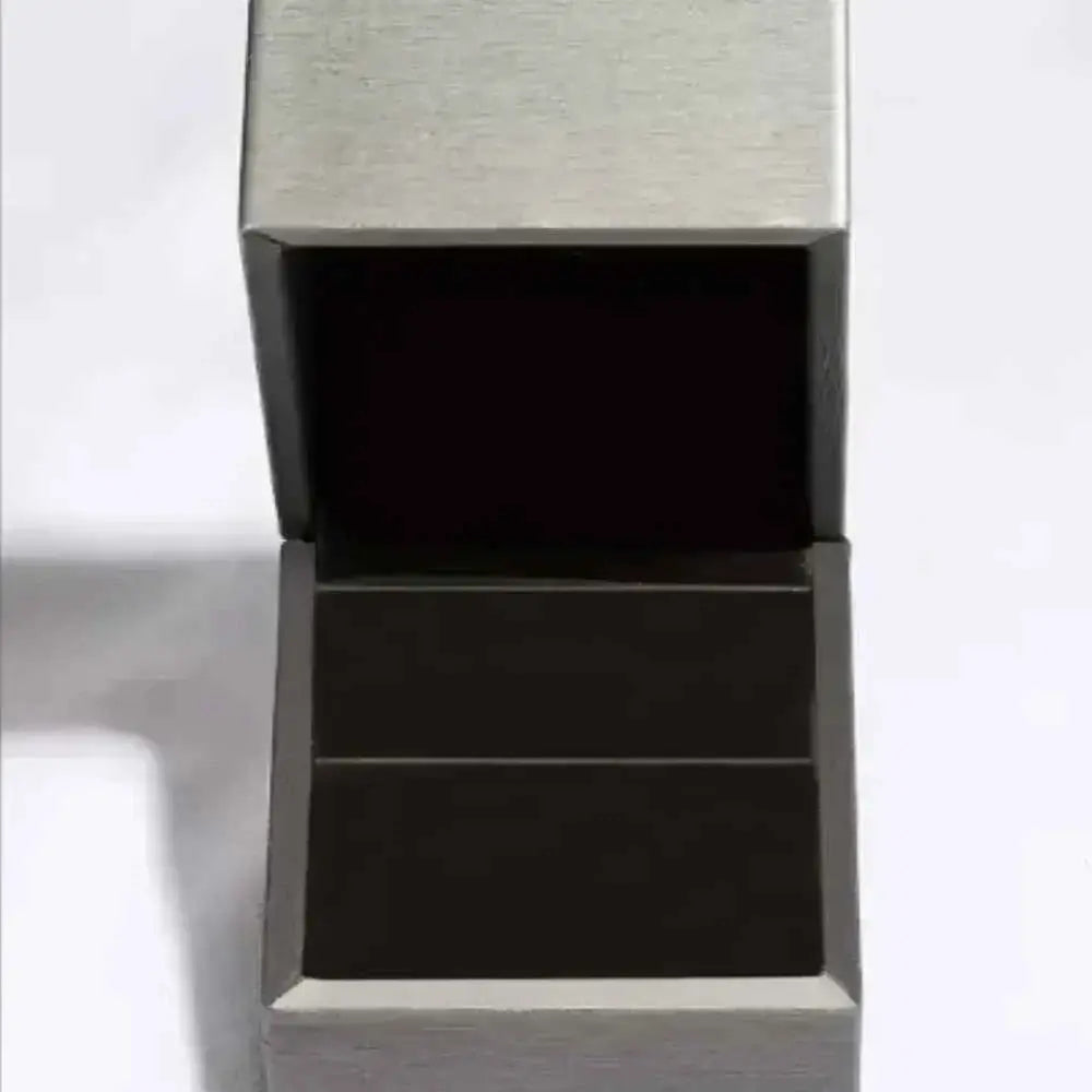 Open silver-tone jewelry box with black velvet interior designed to hold a 10 Carat Moissanite ring securely.