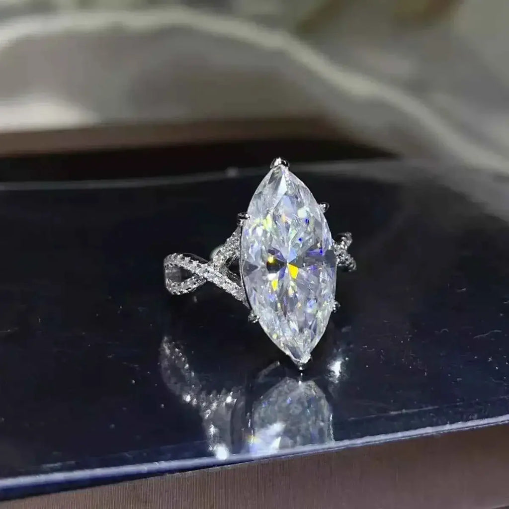 10 Carat Moissanite marquise-cut stone set in a platinum-plated 925 sterling silver ring with an intricate twisted band design.