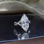 10 Carat Moissanite marquise-cut stone set in a platinum-plated 925 sterling silver ring with an intricate twisted band design.