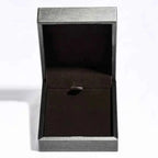Open silver-tone jewelry box with black velvet interior, empty and standing upright with lid open