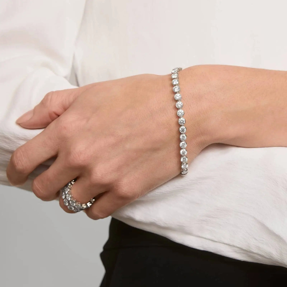 10 CTW moissanite bracelet in white gold plated bezel setting with round brilliant stones worn on wrist