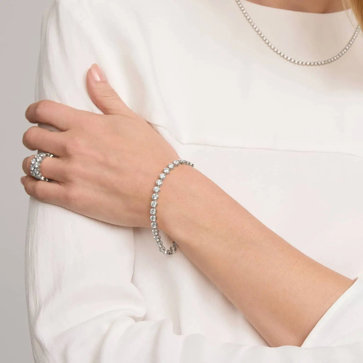 10 CTW moissanite tennis bracelet in 14Kt white gold plating with round bezel-set stones on wrist