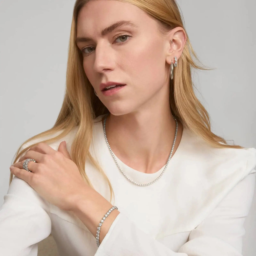 10 CTW moissanite tennis bracelet in white gold plated bezel set with round stones worn on wrist by woman