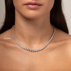 15ct Created Moissanite tennis necklace with graduated round stones in silver-tone metal worn on a female neck