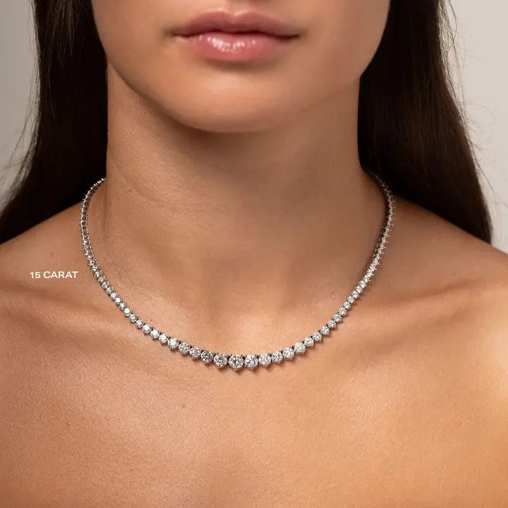 15ct Created Moissanite tennis necklace with graduated round stones in silver-tone metal worn on a female neck