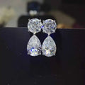 16 Carat Moissanite sterling silver earrings with round and pear-shaped clear stones in a platinum-plated setting