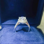 925 sterling silver ring with a large round 2 Carat Moissanite center stone and small side accent stones on the band