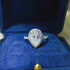 925 sterling silver ring with a pear-shaped 2 Carat Moissanite center stone surrounded by small accent stones