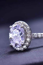 Platinum-plated ring with a large oval 2 Carat Moissanite center stone surrounded by small zircon accent stones