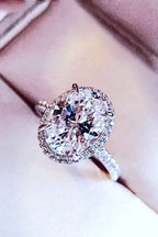 2 Carat Moissanite platinum-plated ring with a large oval center stone surrounded by smaller accent stones on a polished band