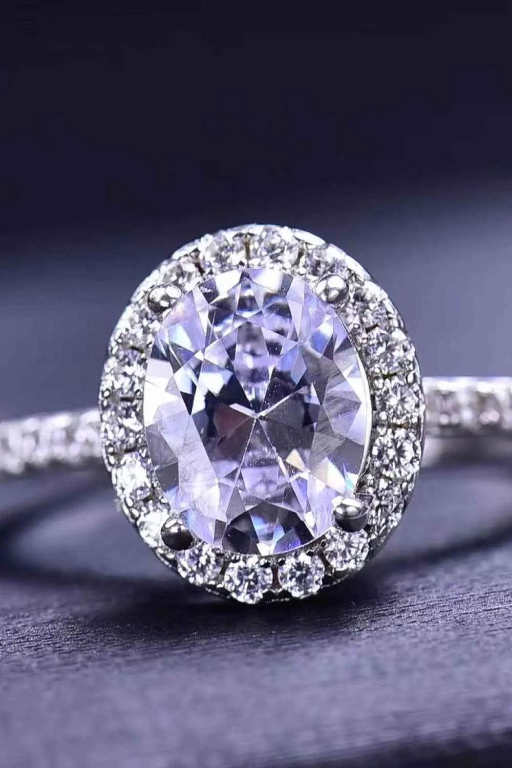 2 Carat Moissanite ring with an oval center stone surrounded by a halo of smaller stones on a polished silver band