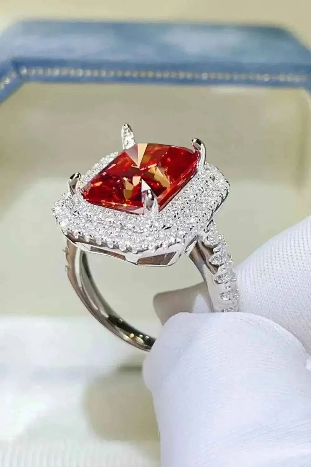 2 Carat Moissanite ring with a square red center gem and surrounding small white stones set in platinum-plated sterling silver