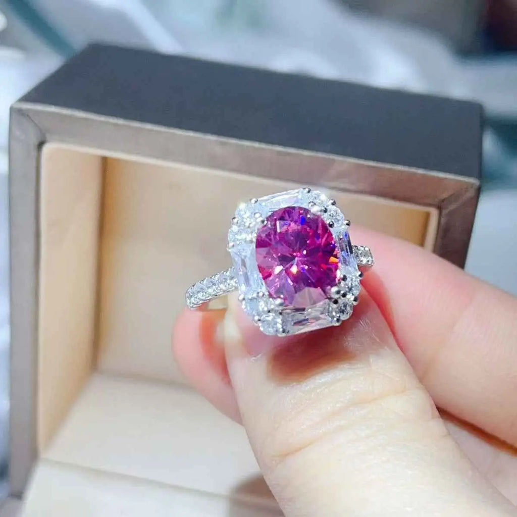 3 Carat Moissanite ring with a large pink center stone, surrounded by small clear stones on a silver band
