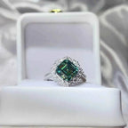 3 Carat Moissanite sterling silver ring with a large square green central stone surrounded by small clear stones in a halo setting