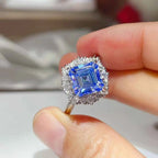 3 Carat Moissanite ring with a large square blue gemstone surrounded by small clear stones on a silver band