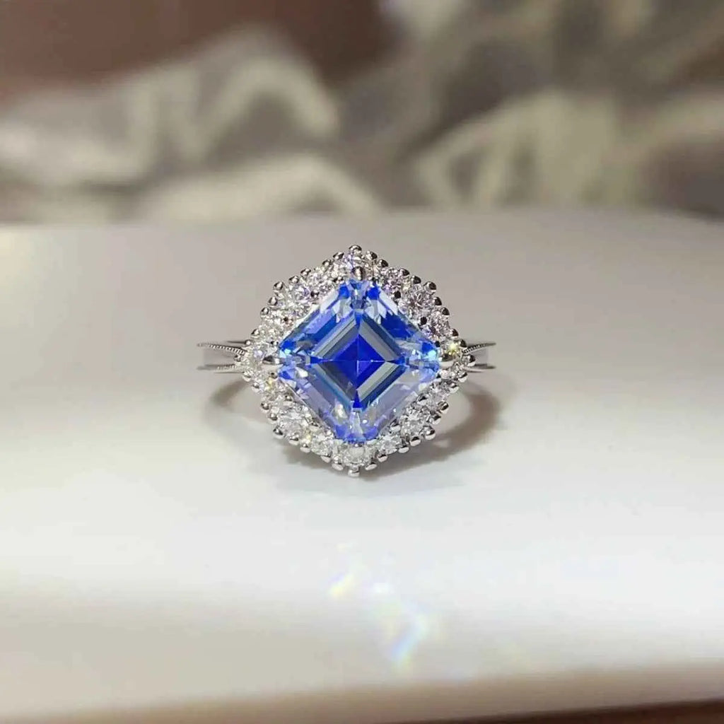 3 Carat Moissanite ring with a large square-cut blue stone surrounded by small clear stones set in silver band