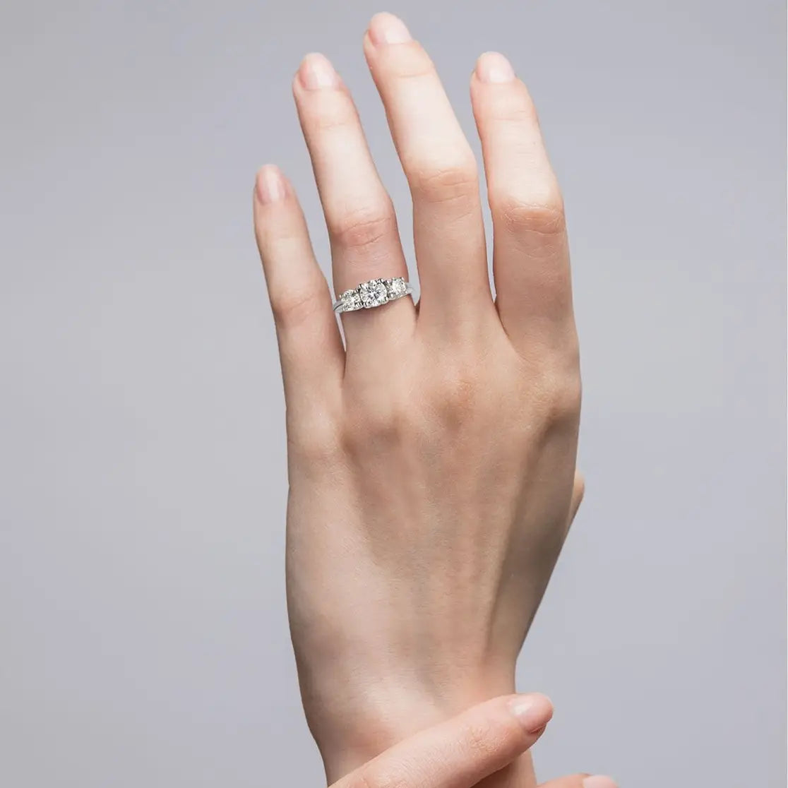 3 CTW AGI Certified three stone engagement ring with three round-cut diamonds set in white gold on hand