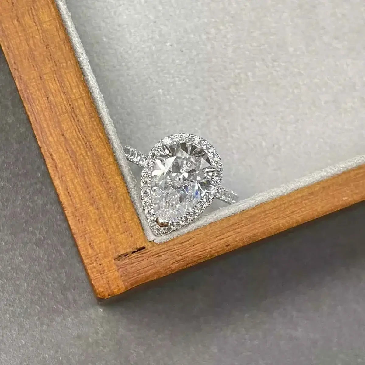 4 Carat teardrop-shaped moissanite ring set in 925 sterling silver with a halo of smaller stones on the band
