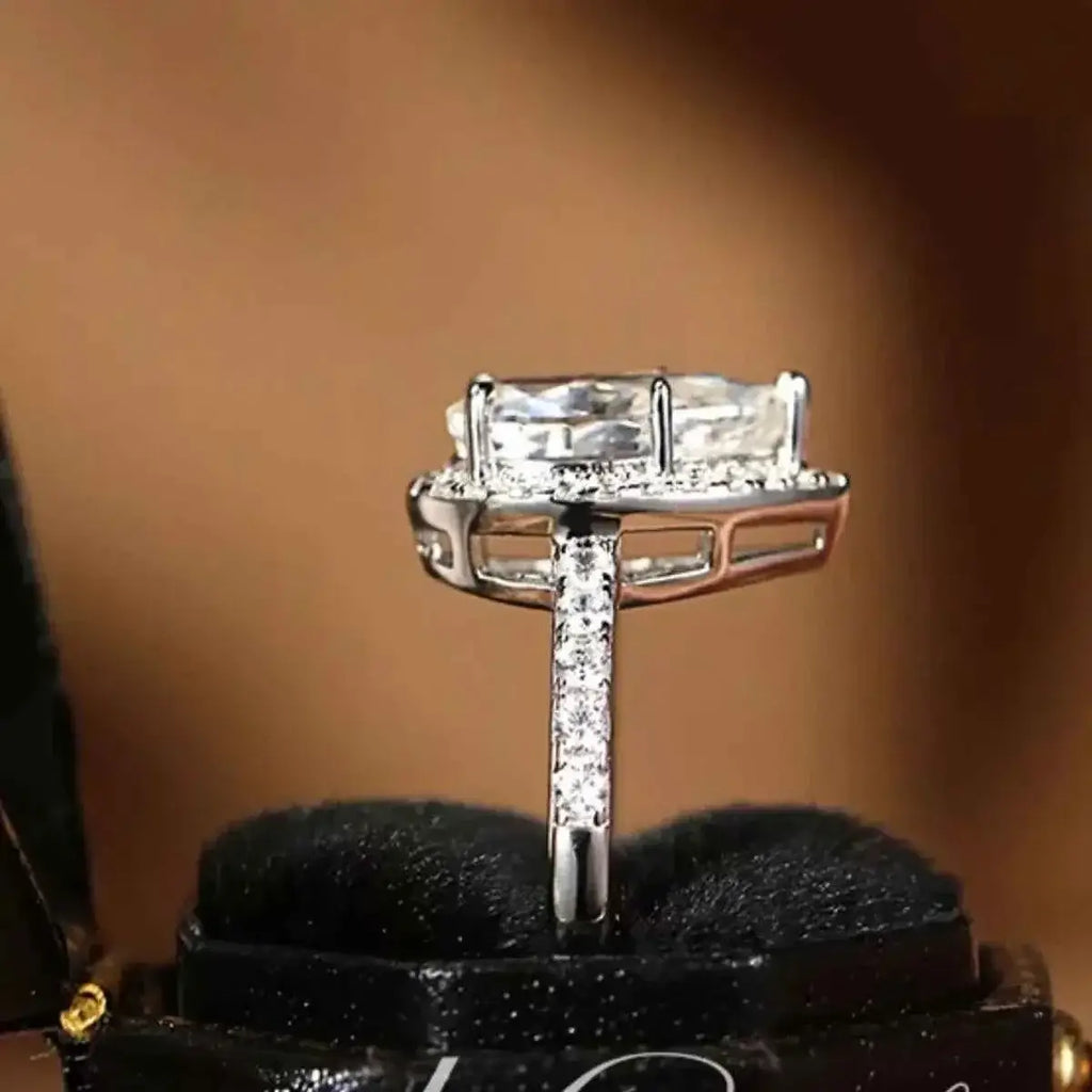 4 Carat sterling silver ring with rectangular clear moissanite center stone and smaller side stones on the band.