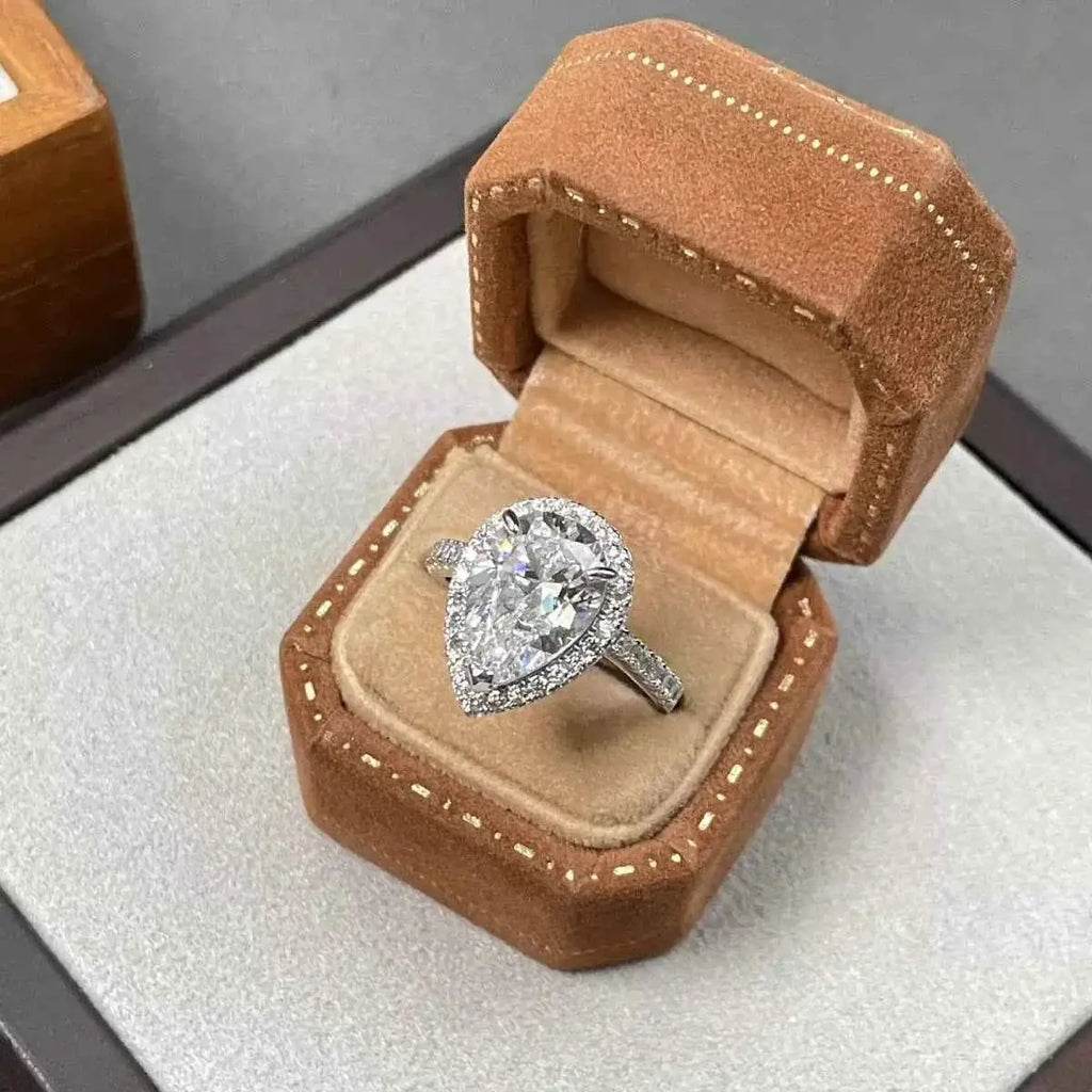 4 Carat teardrop moissanite ring in 925 sterling silver with a halo setting in a brown velvet ring box