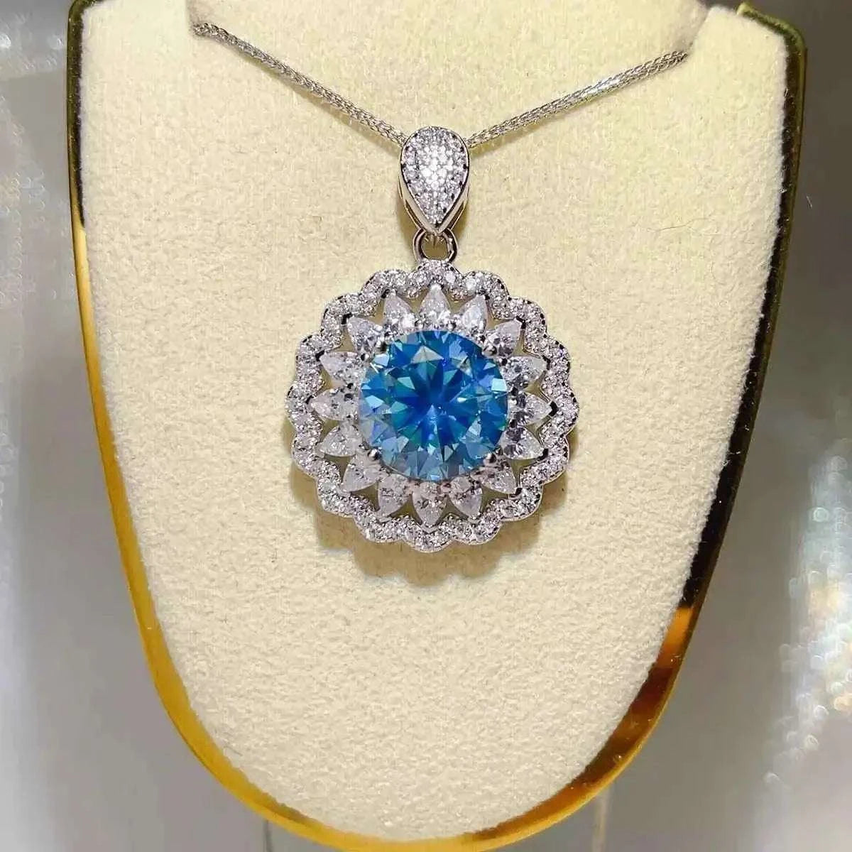 5 Carat sterling silver pendant necklace with a large round blue moissanite center surrounded by multiple layers of clear stones