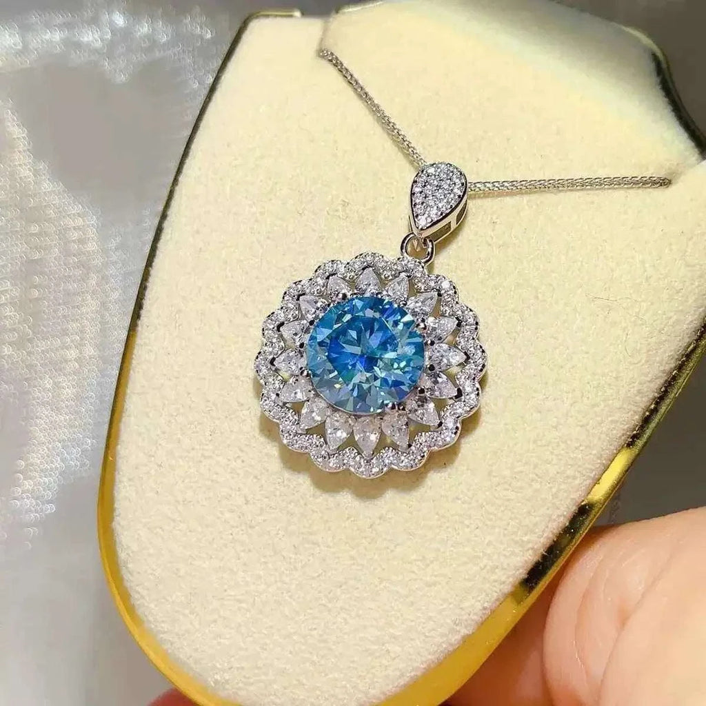 5 Carat sterling silver pendant necklace featuring a large round blue moissanite center stone surrounded by smaller clear stones