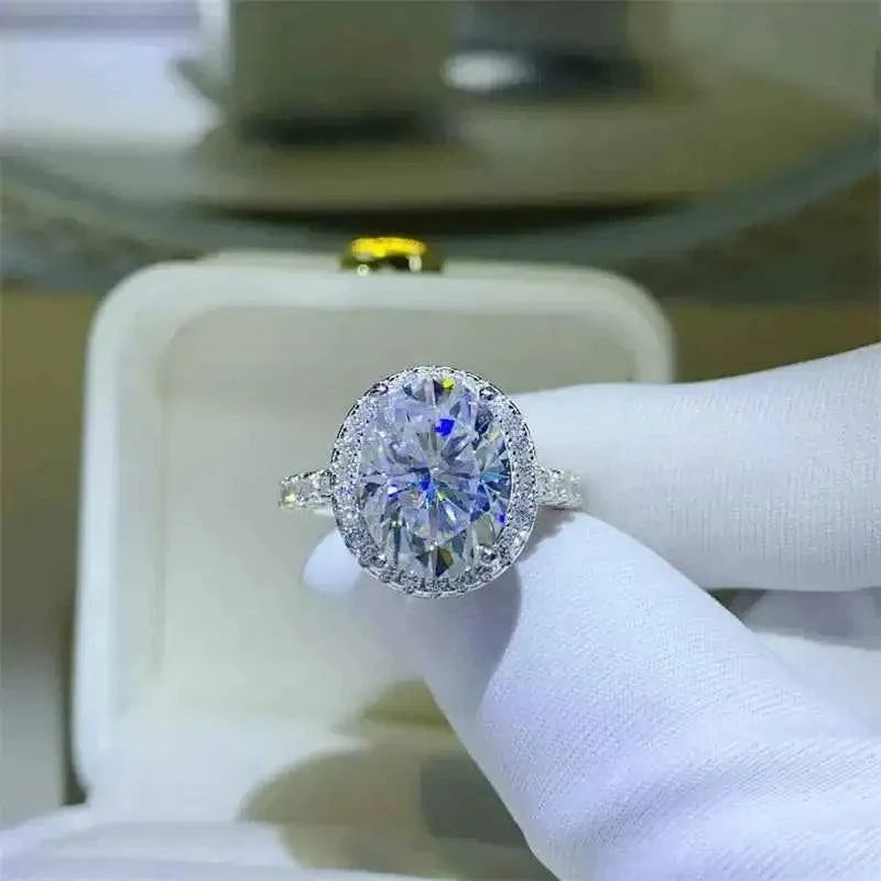 925 sterling silver ring with a large oval 5 Carat Moissanite center stone surrounded by smaller stones in a halo setting