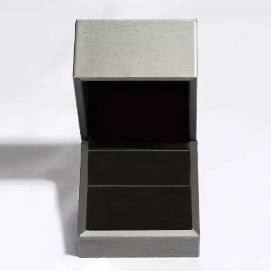 Open silver-colored metallic jewelry box with black interior lining designed to hold a 5 Carat Moissanite ring securely.
