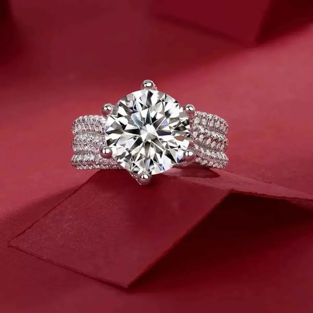 925 sterling silver ring with a large round 5 Carat Moissanite center stone and triple row pavé band detailing