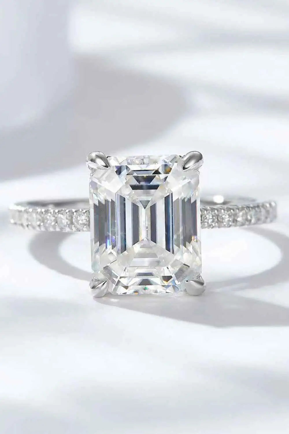 5 Carat Moissanite ring with a large emerald-cut center stone set in platinum-plated 925 sterling silver band with small accent stones