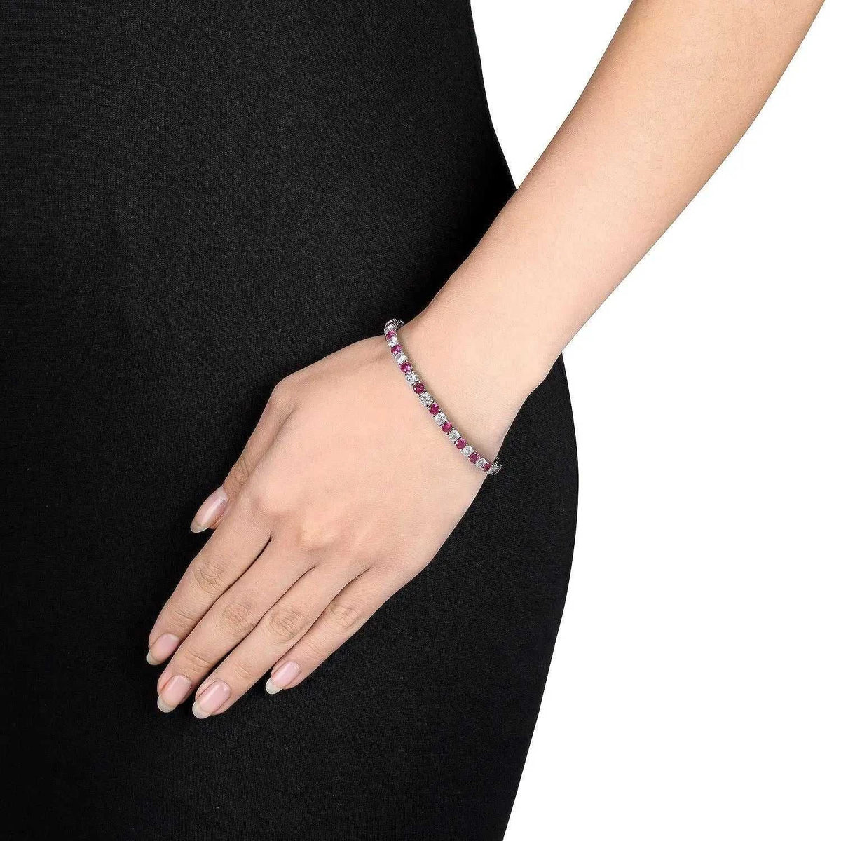 Lab-Created Ruby and white sapphire tennis bracelet with round stones in 14K gold overlay worn on wrist