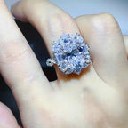 Moissanite ring with large central stone and surrounding smaller stones in Carat 925 Sterling Silver setting on finger
