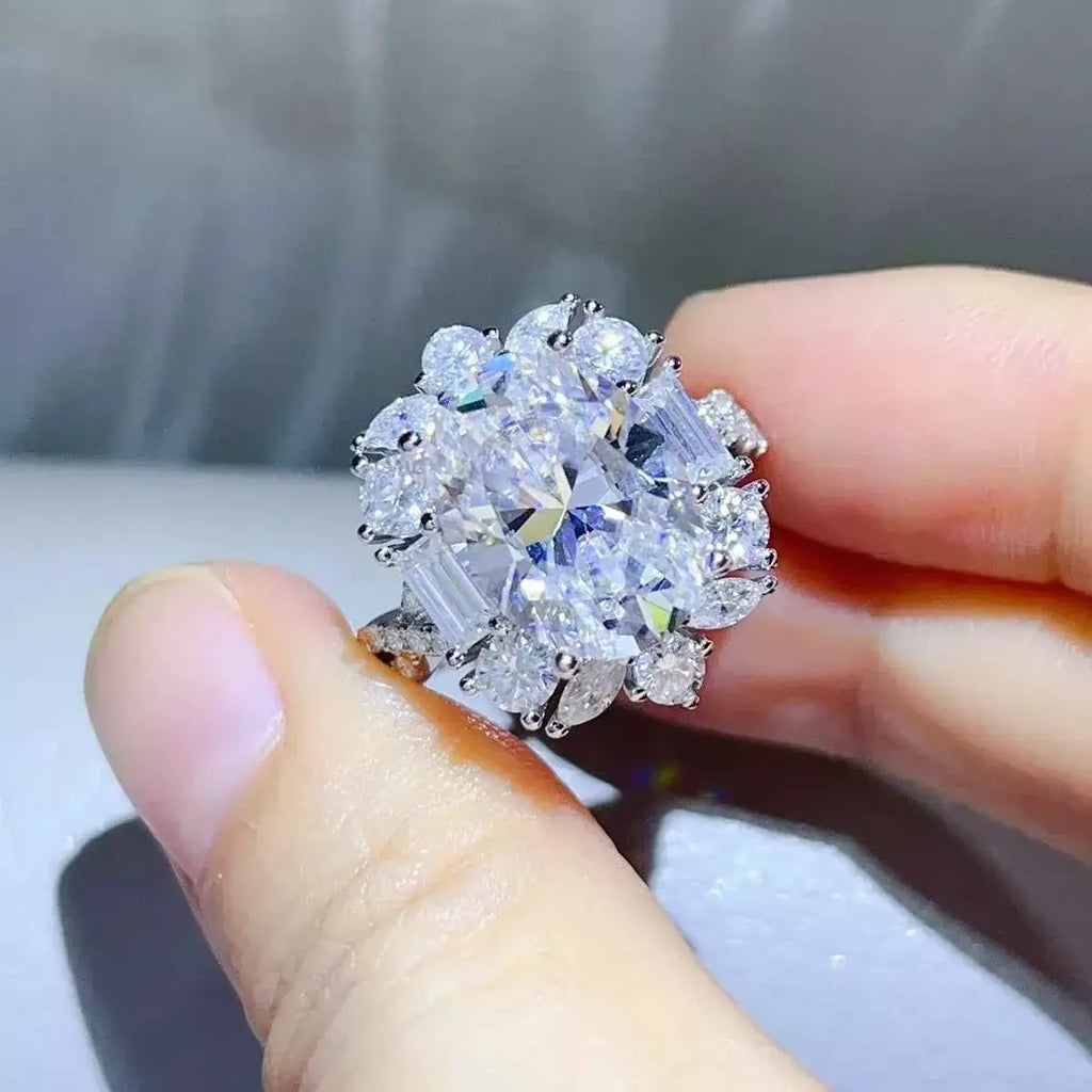 Carat 925 Sterling Silver moissanite ring with a large central round stone surrounded by smaller round and baguette-cut stones in a cluster setting