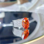 925 sterling silver ring with a large orange oval 8 Carat Moissanite stone and pavé-set small white stones on the band