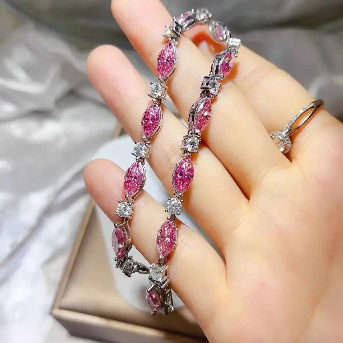 925 Sterling Silver bracelet with alternating pink marquise and clear round gemstones in a delicate linked design worn on a hand