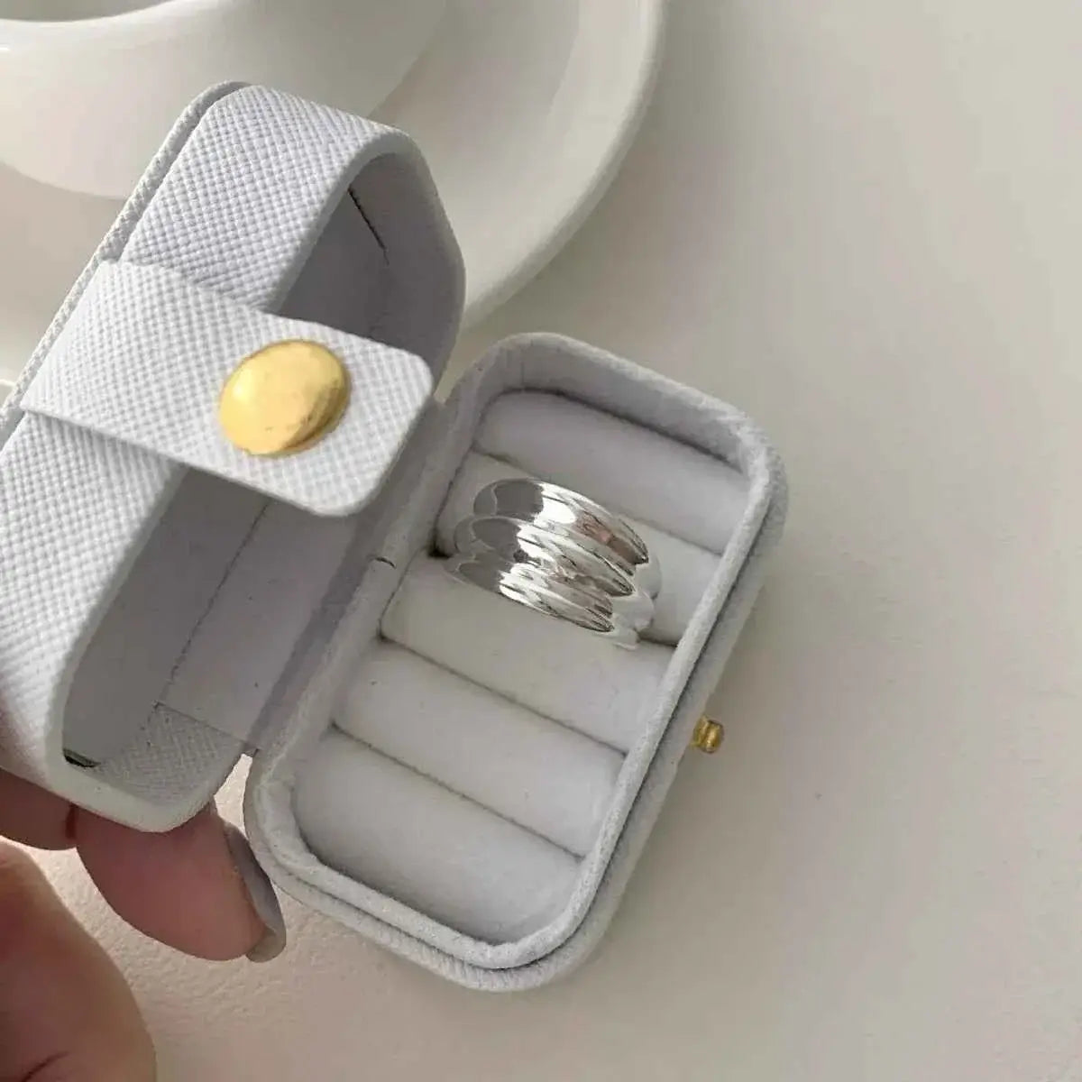 925 Sterling Silver open ring with a layered, rippled design in a white textured jewelry box with gold button clasp