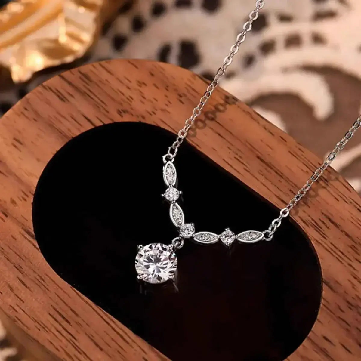 925 Sterling Silver pendant necklace with a delicate chain and a decorative curve of small zircon stones ending in a larger round zircon