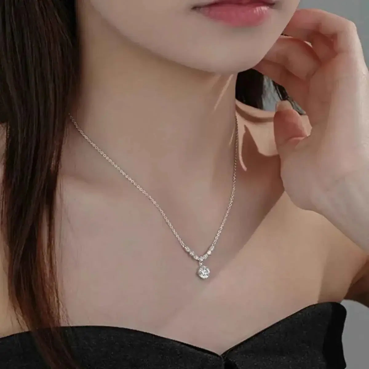 925 Sterling Silver pendant necklace with a clear round zircon on a silver chain worn on a woman's neck