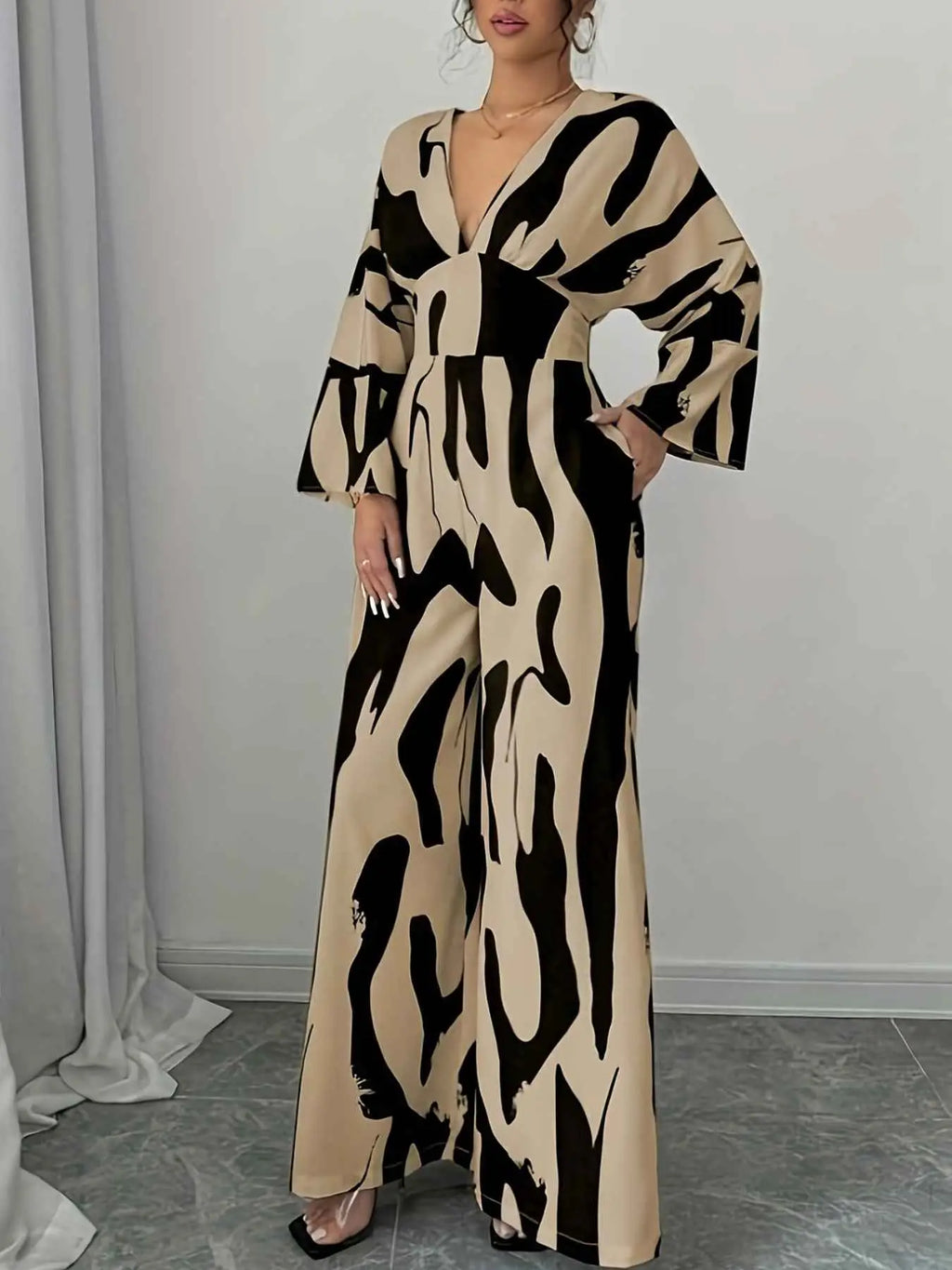 Abstract Print V-Neck beige and black belted wide leg jumpsuit in polyester blend with long sleeves and deep v-neckline