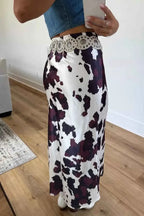 Abstract Print Western long skirt in white with black and dark purple cow print pattern, featuring a silver concho belt
